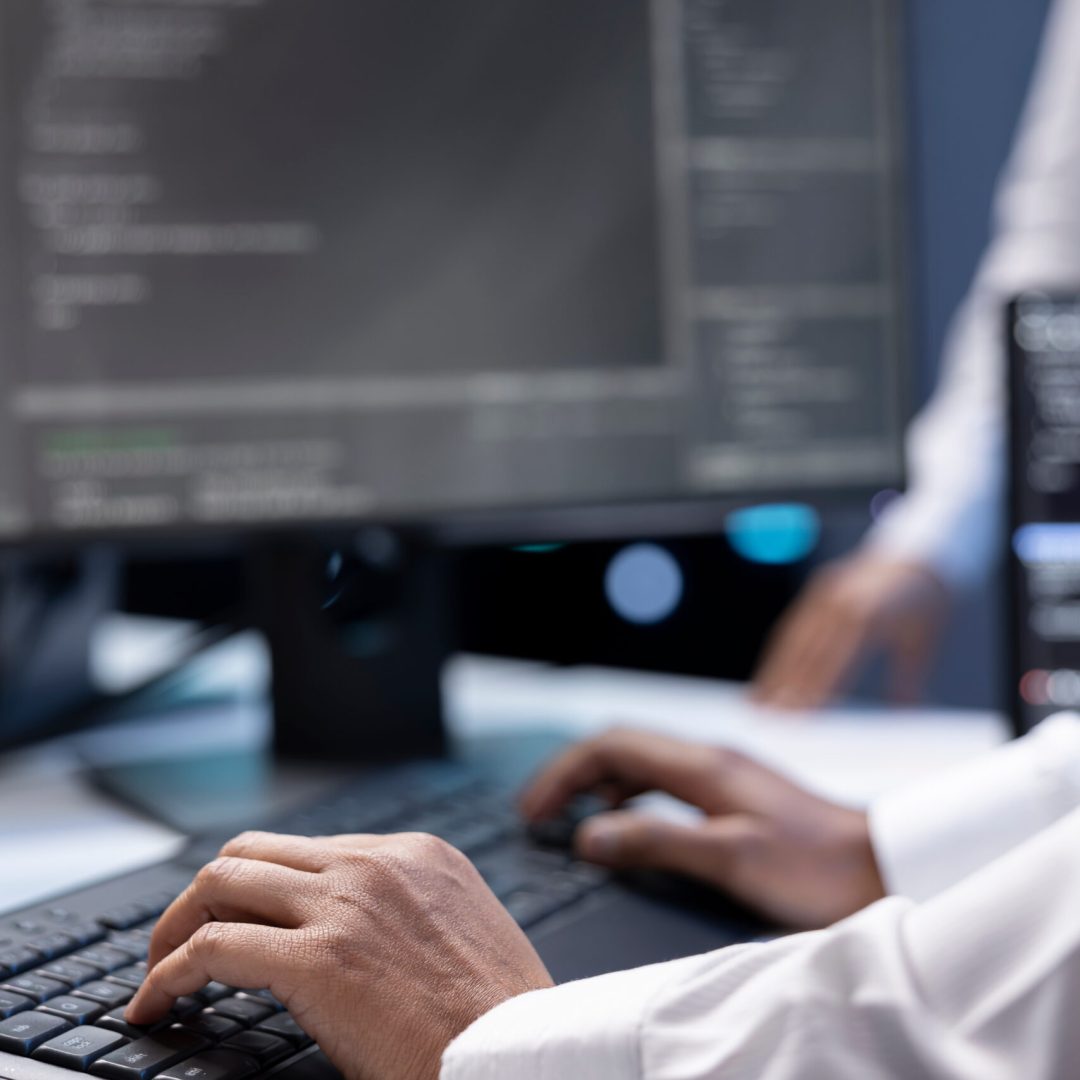 Admin in data center checking equipment performance on computer after upgrading infrastructure. Close up shot of IT employee doing maintenance on storage arrays in servers room
